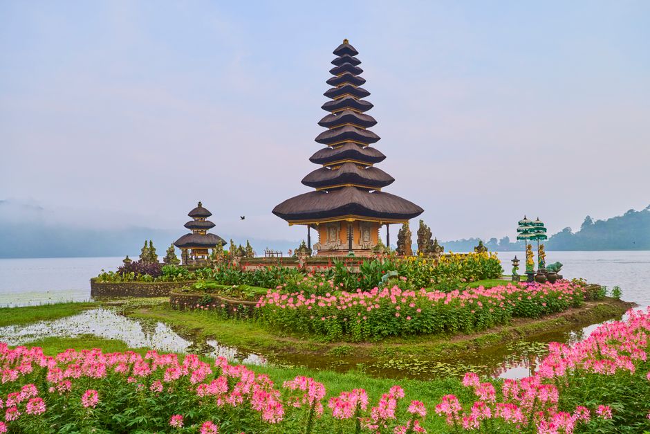 Beautiful Ulun Danu Beratan Temple in Bali, surrounded by colorful flowers and a serene la