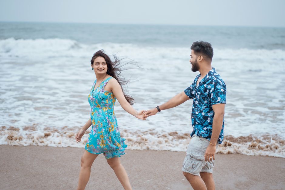 Smiling couple holding hands and walking along the beach in Puri, India. Perfect for vacation imagery.