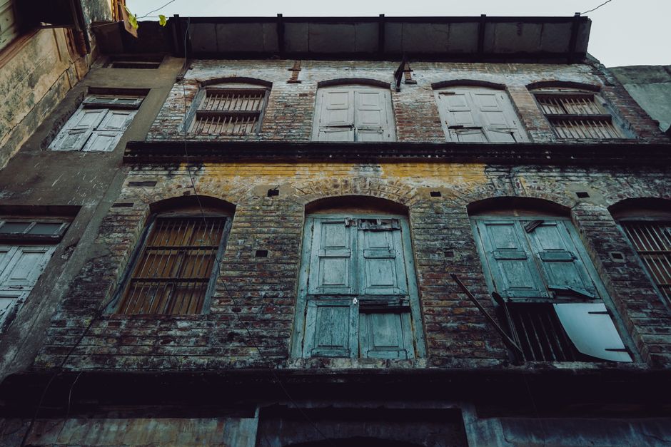 An old and weathered building exterior in Ahmedabad, India, captured from a low angle.