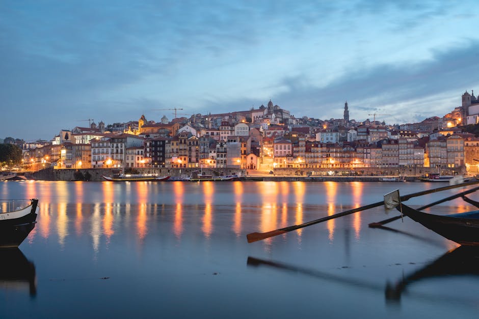 A captivating view of Porto's waterfront showing vibrant city lights reflecting on the Douro River at dusk.
