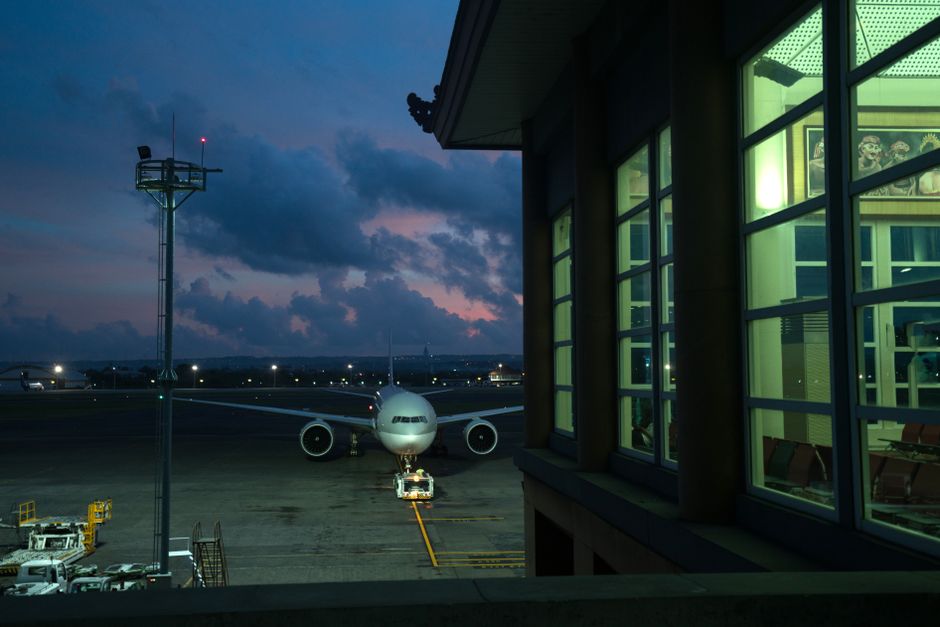 Modern plane parking on stand near assigned gate in modern airport terminal at night