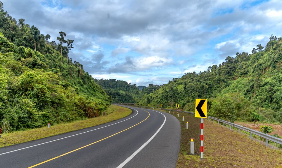 Scenic curved road through mountainous landscape, ideal for travel and adventure imagery.