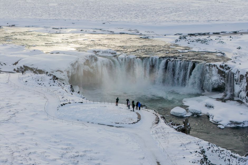 Breathtaking aerial view of the frozen Goðafoss waterfall in winter, Iceland.