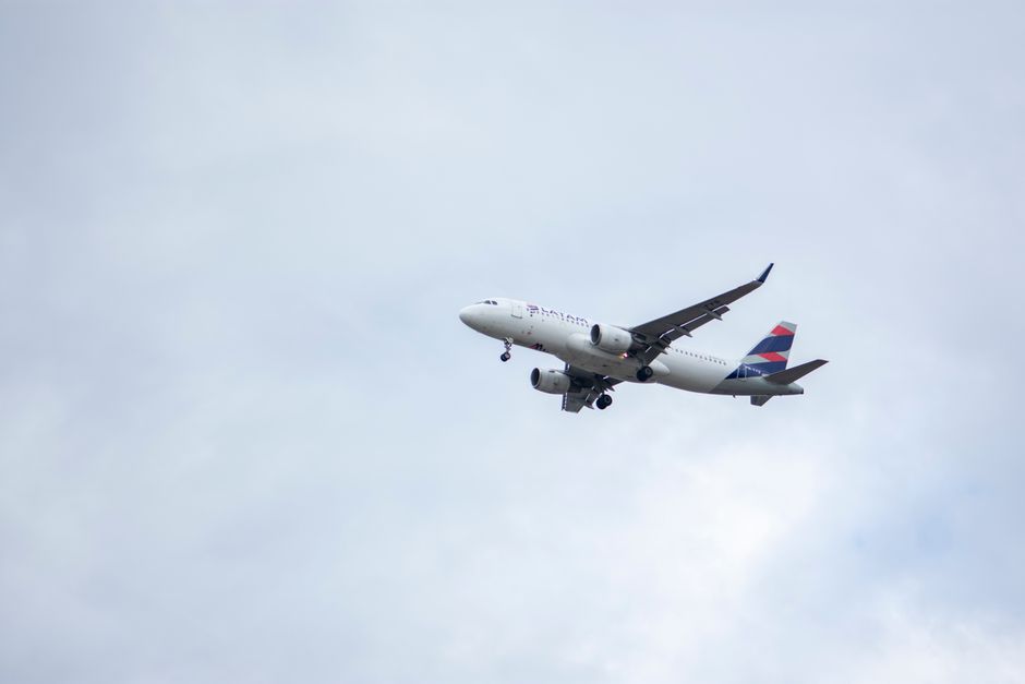 LATAM Airlines commercial airplane soaring through overcast skies near Londrina, Brazil.