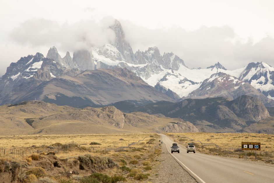 Discover the breathtaking landscape of El Chaltén with Mount Fitz Roy in view as cars journey through this iconic region.