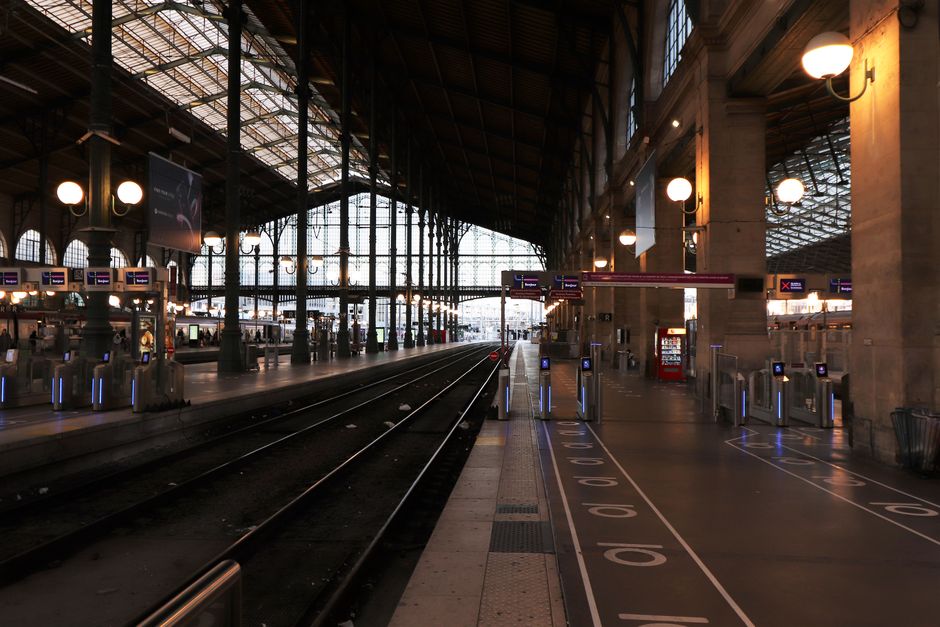 View of the interior of Gare du Nord railway station in Paris, showcasing tracks and architecture.